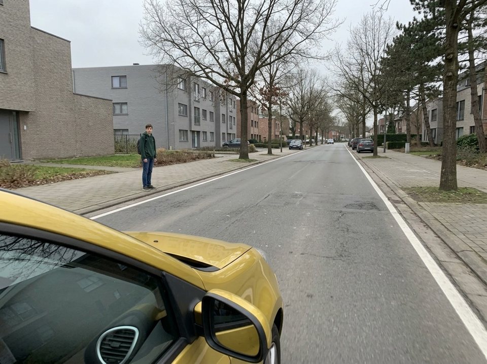 Where there is no zebra crossing, pedestrians must give way to road traffic. The pedestrian waiting at the kerb must let the approaching car pass before crossing.
